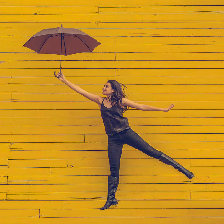 a person extending their arm and holding an umbrella in front of a yellow wall_archetypal branding